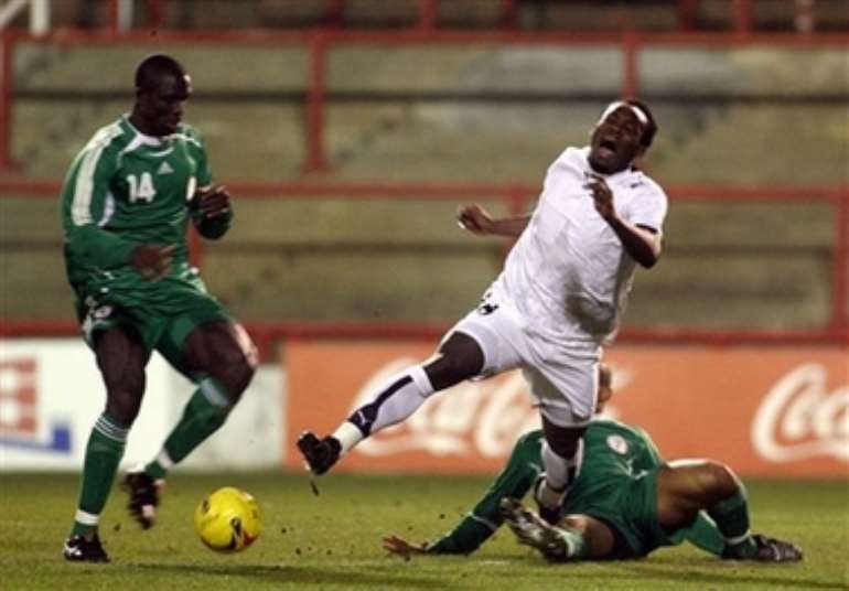 Ghana's Michael Essien, center, is brought down by Nigeria's George Abbey during their International friendly soccer match at Griffin Park Stadium, London, Tuesday Feb. 6, 2007. (AP Photo/Graham Hughes )