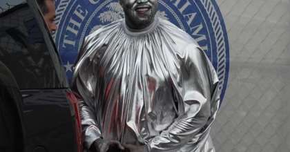 Kanye West wears silver body paint and a billowing silver robe as he appears at his latest opera in Miami. (MEGA)