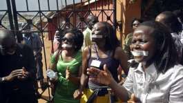 Employees of the Daily Monitor newspaper with their mouths taped shut, during a protest against the closure of their premises by the Uganda government, in the capital Kampala, on 20 May, 2013. - Reuters/James Akena