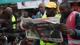 A Kenyan reads national daily newspaper The Standard, with a headline reporting the election of Kenyas 5th President elect William Ruto, in Eldoret, in August 2022. - AFP - SIMON MAINA