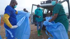 A health worker sprays a colleague with disinfectant after taking part in a burial service for a 3-year-old who died of Ebola in Bunia, Ituri province of eastern Congo, on August 18, 2026. -  Dieudonne Dirole, AP Photo