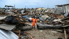 A boy in the Ivorian team jersey at his demolished home in Koumassi Campement.  By Sia KAMBOU (AFP)