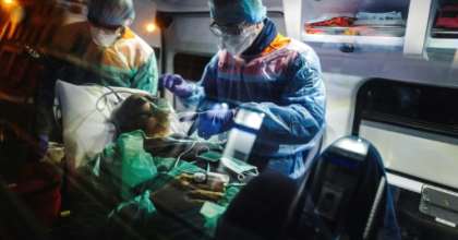 A French first aid worker from the Protection Civile Paris Seine holds an oxygen mask over the mouth and nose of a male patient suspected of being infected with COVID-19 a he lies in an ambulance. By Lucas BARIOULET (AFP)