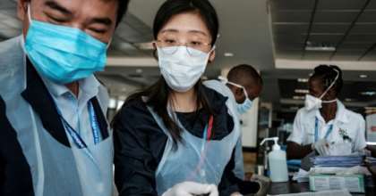Chinese embassy officials help screen incoming passengers for the new coronavirus as they arrive at Entebbe Airport in Uganda on March 3, 2020. By SUMY SADURNI (AFP/File)